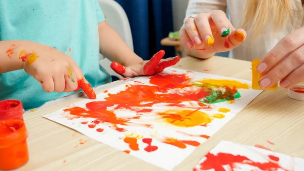 Primo piano di disegno adulto e bambino con le mani e le dita utilizzando vernice colorata su carta bianca. Concetto di educazione creativa e sviluppo delle competenze artistiche — Foto Stock