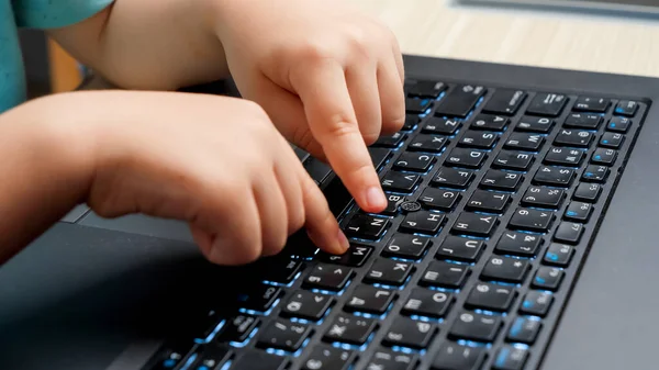 Closeup of little child fingers pressing buttons on laptop keyboard. Child studying and learning using laptop computer. — Stock Photo, Image
