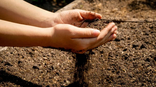 Gadis remaja tangan memegang tanah subur di lapangan. Konsep pertumbuhan, perlindungan lingkungan dan penanaman organik di pertanian — Stok Foto