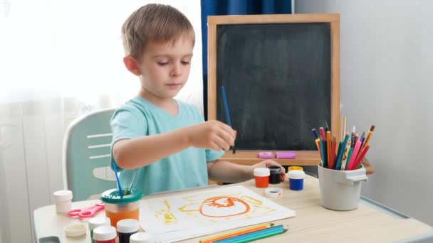 Um rapazinho a desenhar na sala de aula. Criança criativa a pintar arte. Educação em casa durante o confinamento — Vídeo de Stock