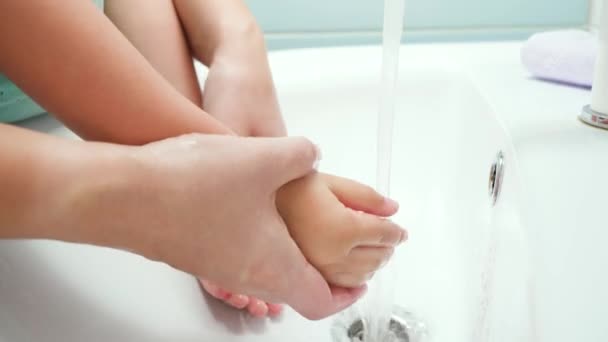 Een close-up van moeder die handen wast aan haar kleine peuter zoon. Concept van kinderhygiëne en gezondheidszorg — Stockvideo