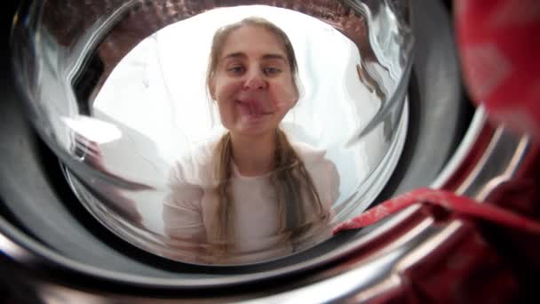 Ritratto di bella casalinga sorridente che toglie il vestito dalla lavatrice in bagno. Lavori domestici e routine quotidiana. — Video Stock