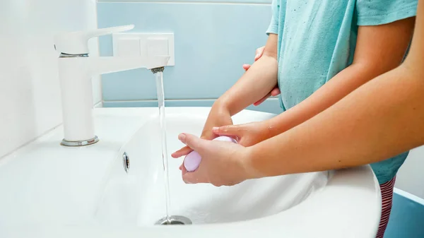 Fechar-se de vocêem outros lavar as mãos de seus filhos com sabão na pia do banheiro. Conceito de saúde e higiene — Fotografia de Stock