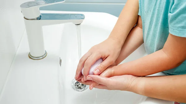 CLoseup de mère enseignant et montrant à son petit fils comment se laver les mains. Enfant utilisant du savon antibactérien tout en se lavant les mains dans la salle de bain — Photo