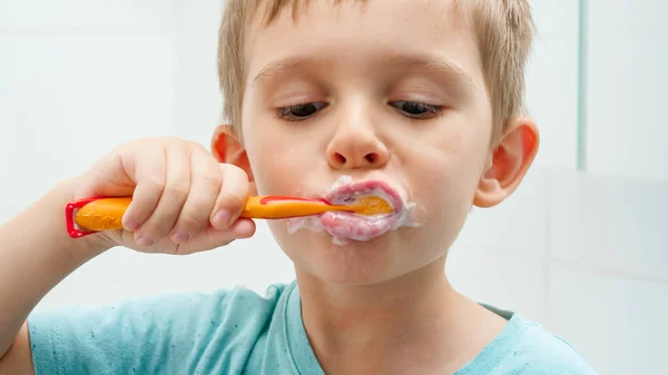 Retrato de niño divertido limpiando y cepillándose los dientes por la mañana. Concepto de higiene dental y salud infantil — Foto de Stock