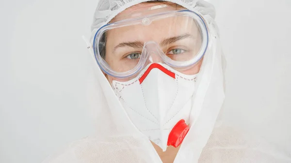 Coronavirus ve covid-19 'a karşı koruyucu giysi, solunum maskesi ve gözlük takan kadın doktor ya da sağlık görevlisi. — Stok fotoğraf
