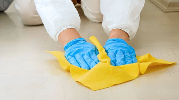 女管家或家庭主妇穿着医用手套在家中用化学洗涤剂或清洁剂消毒和清洁地板. — 图库照片