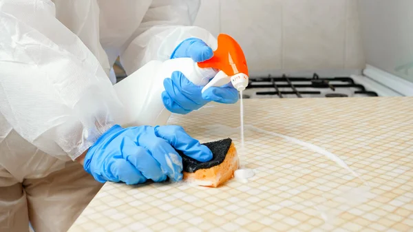 Primo piano di disinfezione tavolo da cucina con detergente chimico. Lotta contro virus e batteri a casa. Pandemia globale e covid-19 — Foto Stock