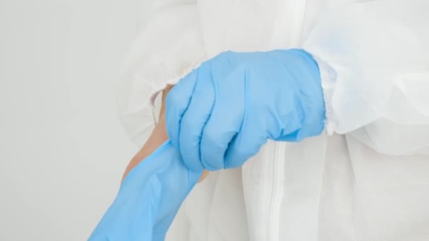 CLoseup of female docto putting on protective rubber gloves in hospital. You should protect with gloves and wear mask against covid-19 and coronavirus — Stock Video