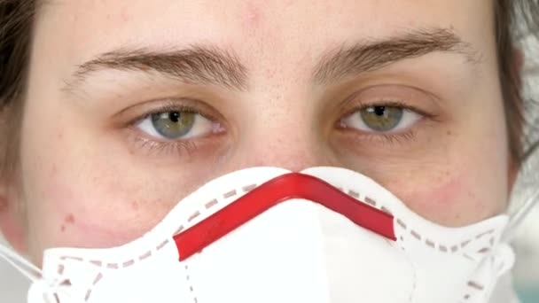 보호용 고글, 양복, 마스크를 착용하고 카메라를 보고 있는 여성 의사의 클로즈업 사진. 세계적 유행병 및 국제적 유행병과의 싸움 — 비디오