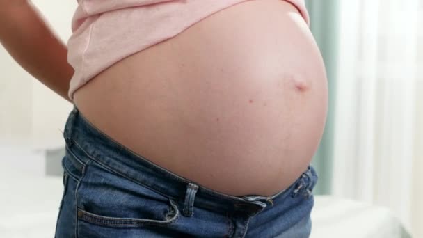 Close-up van een zwangere vrouw die haar maten controleert met gele meetlint. Concept van zwangere gezondheidszorg en dieet — Stockvideo