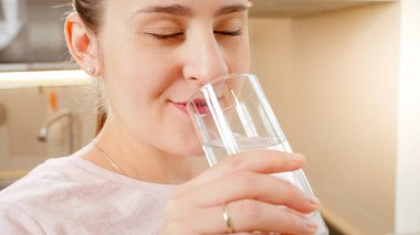 Güzel genç bir kadının portresi. Sabahları mutfaktaki bardaktan temiz su içiyor.