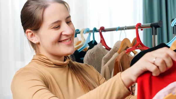 Portrait of smiling woman choosing beautiful dress and posing with it in shopping mall or clothes store — Stock Photo, Image