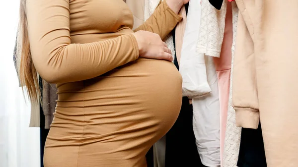 Închiderea unei femei însărcinate frumoase care are cumpărături și caută haine materne pentru a cumpăra — Fotografie, imagine de stoc