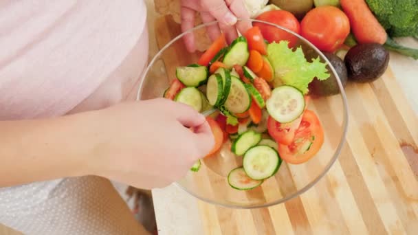 Zwangere vrouw wacht op baby koken en het eten van verse groentesalade in de keuken. Concept van gezonde levensstijl en voeding tijdens de zwangerschap — Stockvideo