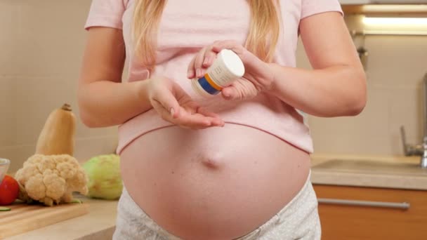 CLoseup těhotné ženy nalévání vitamínů pilulky na ruce z plastové lahve kontejneru. Koncepce zdravého životního stylu, výživy a hydratace během těhotenství — Stock video