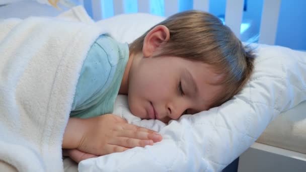 Porträt eines ruhigen kleinen 5-jährigen Jungen, der schläft und nachts gute Träume hat. Schlafenszeit für Kinder — Stockvideo