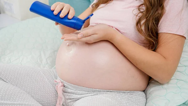 アリのストレッチマークを適用する妊婦の閉鎖は彼女の大きな腹にクレームをマーク.赤ちゃん、妊娠、医療を期待する概念. — ストック写真