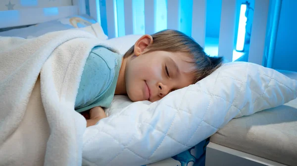 Retrato de un lindo niño acostado en la cama y durmiendo por la noche. Calma hermosa niña en la cama —  Fotos de Stock