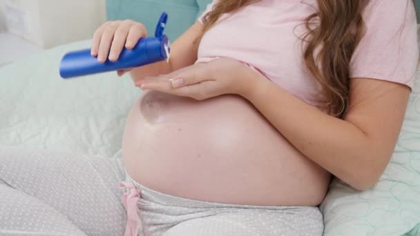 アリのストレッチマークを適用する妊婦の閉鎖は彼女の大きな腹にクレームをマーク.赤ちゃん、妊娠、医療を期待する概念. — ストック動画