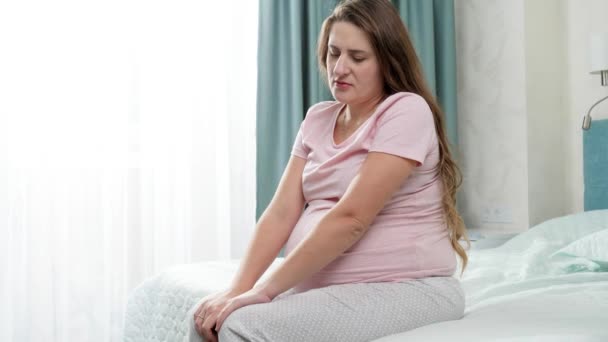 Mulher grávida triste sentado e tremendo na cama. Conceito de depressão materna e gravidez. — Vídeo de Stock