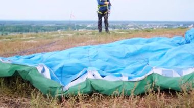 Paraşütçü indikten sonra çimlerin üzerinde yatan paraşüt kanadının yakın plan görüntüsü.