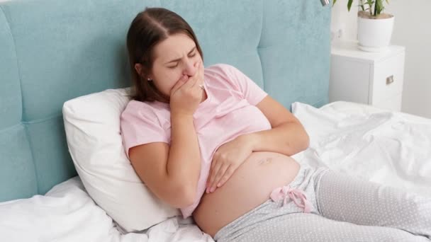 Jeune femme enceinte se sentant malade couchée au lit et toussant. Soins de santé et intoxication pendant la grossesse — Video