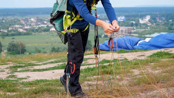 Paracaídas macho doblando y preparando su paracaídas antes de saltar. Concepto de deporte extremo y afición a la adrenalina — Foto de Stock