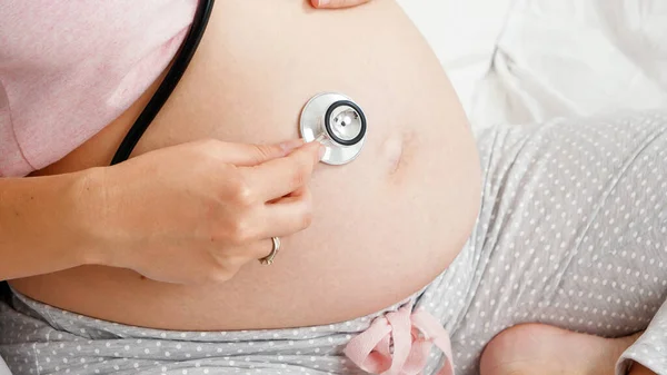 봉합 의사가 청진기를 사용 해서 임신 한 여성 환자의 말을 듣고 있습니다. 임신 기간 동안의 건강 및 건강 검진의 개념. — 스톡 사진