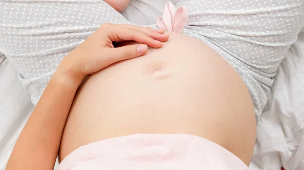 Jonge zwangere vrouw verwacht een kind streelt en zachtjes aanraken van haar buik. Prachtige zwangerschap en verwachting van de baby — Stockfoto