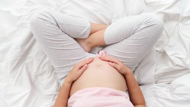 子供を期待して妊娠中の若い女性は、彼女の腹に撫でて優しく触れます.美しい妊娠と赤ちゃんの期待 — ストック動画