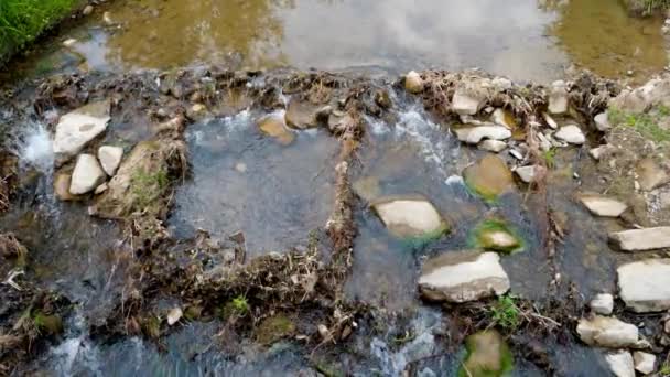 Vista superior del río de montaña sucio y contaminado. COncept de desastre ecológico. escombros y basura plástica que yace sobre rocas en el río. — Vídeo de stock