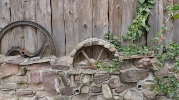 오래 된 항아리, 바퀴 및 전통적 인 물건들을 둥그스럼 한 통나무로 만든 장작더미 옆에 두었다. 완벽 한 소박 함이나 시골 배경 — 비디오