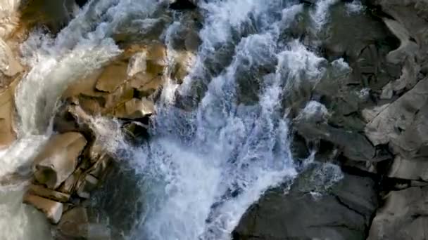 Zeitlupe des schnellen und schnellen Wasserstroms, der über scharfe Felsen und Klippen fließt. — Stockvideo