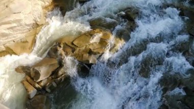 Hızlı dağ nehri ve şelalenin kayalıklara ve kayalara düşüşünün aşırı yavaş çekimi