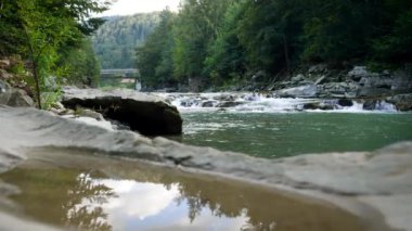Çam ormanlarındaki dağ nehrinde kayalardan ve akarsudan oluşan güzel bir manzara.