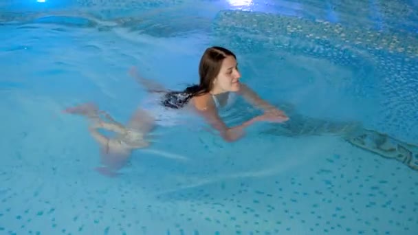 Повільний рух розслаблюючої красивої жінки в басейні з чистою водою в курортному спа-центрі готелю — стокове відео