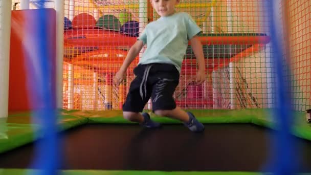 Mouvement lent de saut garçon de 5 ans jouant et s'amusant sur le trampoline. — Video