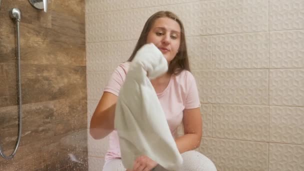 Jovem empregada limpeza e limpeza manchas na porta de vidro no chuveiro no quarto do hotel. — Vídeo de Stock