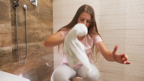 Jovem empregada doméstica limpeza e lavagem de porta de vidro no chuveiro no banheiro do quarto do hotel. — Vídeo de Stock