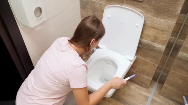 Jeune femme en pyjama se sentant malade vomissant dans les toilettes après avoir fait un test de grossesse. Intoxication et nausées pendant la grossesse — Video