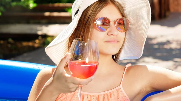 Porträt der schönen msiling yougn girl trinken Cocktail, während Sie sich im Schwimmbad an heißen Sommertagen entspannen. Konzept für glückliche Sommerferien und Urlaub — Stockfoto