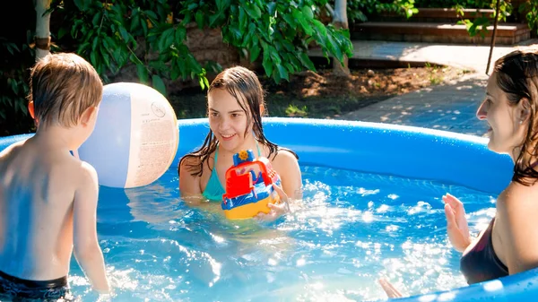 Küçük çocukla oyuncak gemi oynayan mutlu bir aile. Açık havuzda. Mutlu ve neşeli aile kavramı yaz tatili ve tatil — Stok fotoğraf