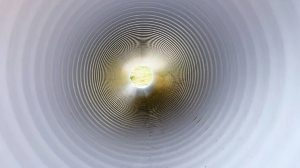 View from inside of plastic water pipe. Light in the end of tunnel.