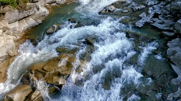 Poderoso arroyo de montaña rompiendo y fluyendo sobre rocas afiladas y acantilados en las montañas — Foto de Stock