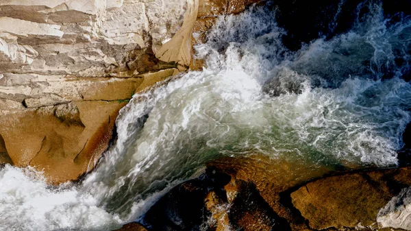 Cours d'eau rapide et rapide qui coule sur des rochers et des falaises pointus — Photo