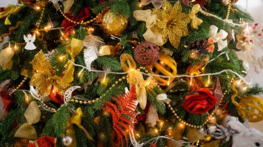 Evdeki Noel ağacını süsleyen çelenk üzerindeki sarı ışıkların yakın çekimi.