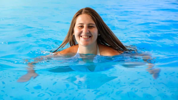 Avkopplande vacker kvinna i poolen med klart vatten på hotellets spa — Stockfoto