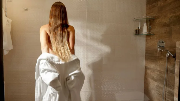 Gyönyörű szexi nő leveszi a fürdőköpenyt, és séta a zuhany alatt — Stock Fotó