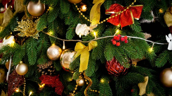 Primer plano de hermoso árbol de Navidad decorado con un montón de bolas, guirnaldas ligeras y cintas. Fondo o telón de fondo de vacaciones de invierno — Foto de Stock